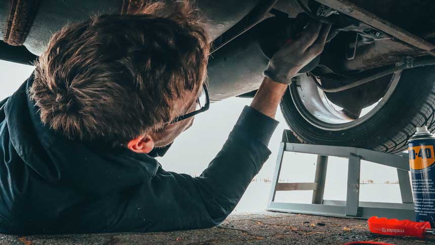 Mechanic Inspecting Exhaust Pipe